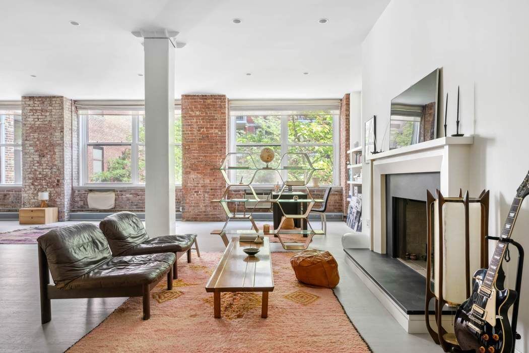 525 West 22nd Street, Unit 3AF Manhattan, NY 10011 - Photo 16 of 20 a living room with furniture a large window and a fireplace