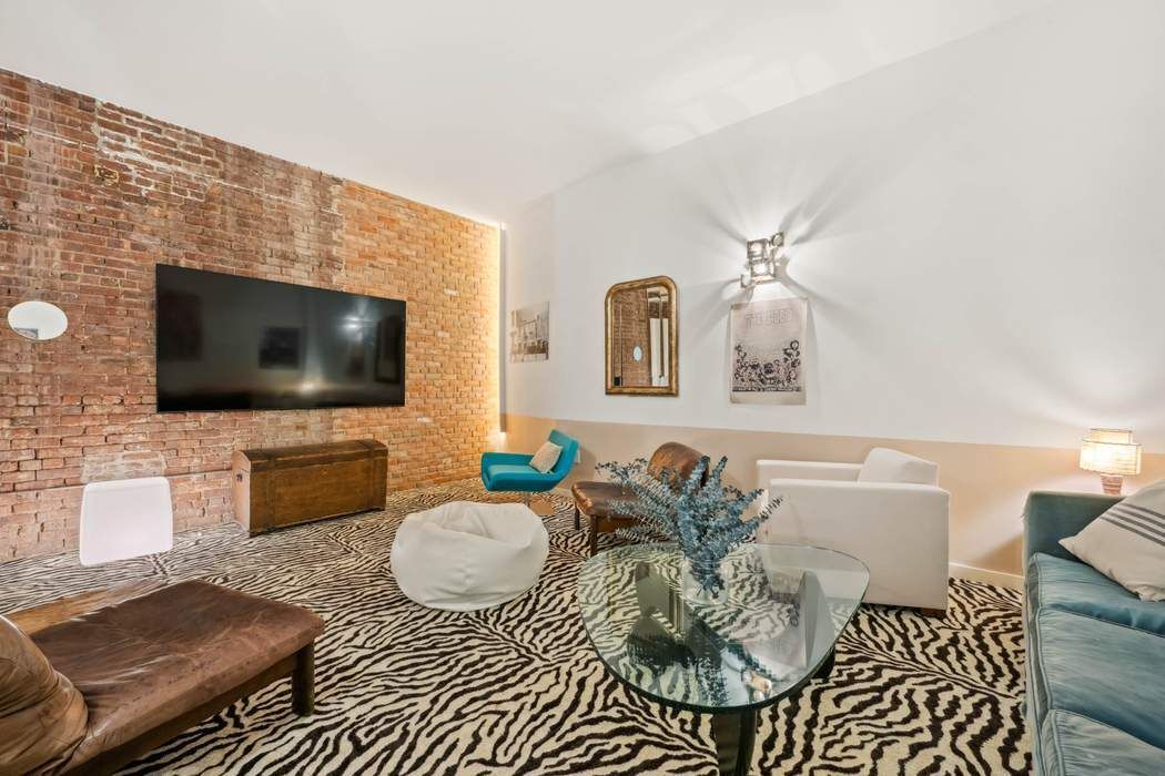 525 West 22nd Street, Unit 3AF Manhattan, NY 10011 - Photo 17 of 20 a living room with furniture and a flat screen tv