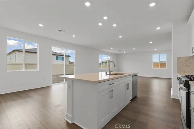 a view of kitchen with cabinets stainless steel appliances and wooden floor