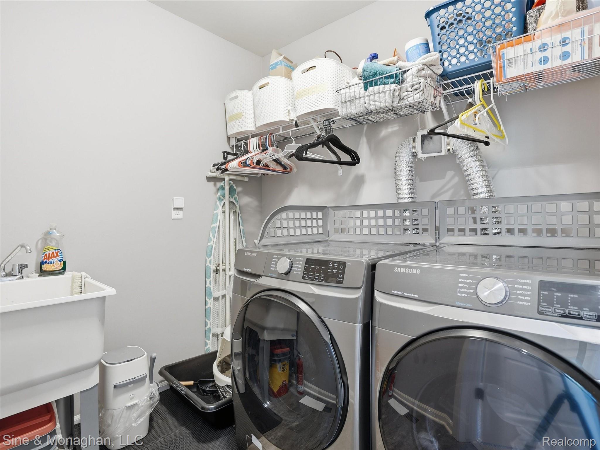 24827 Ivy Road Novi, MI 48375 - Photo 22 of 38 Dedicated laundry room featuring a utility sink, wall-mounted shelving, and a dark floor