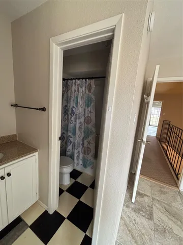 a bathroom with a toilet and a shower curtain
