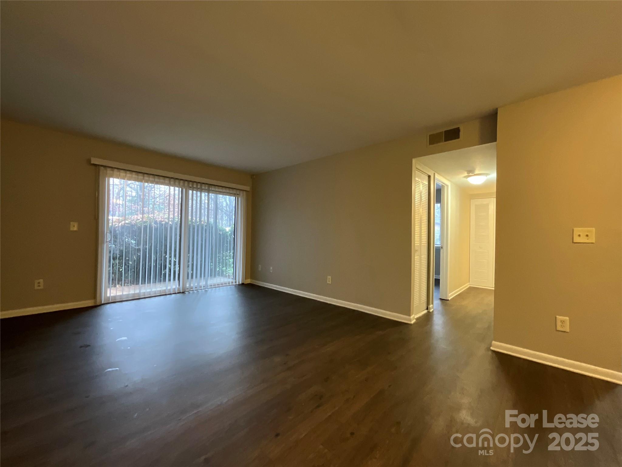 238 Orchard Trace Lane, Unit 2 Charlotte, NC 28213 - Photo 3 of 9 a view of an empty room with wooden floor and a window