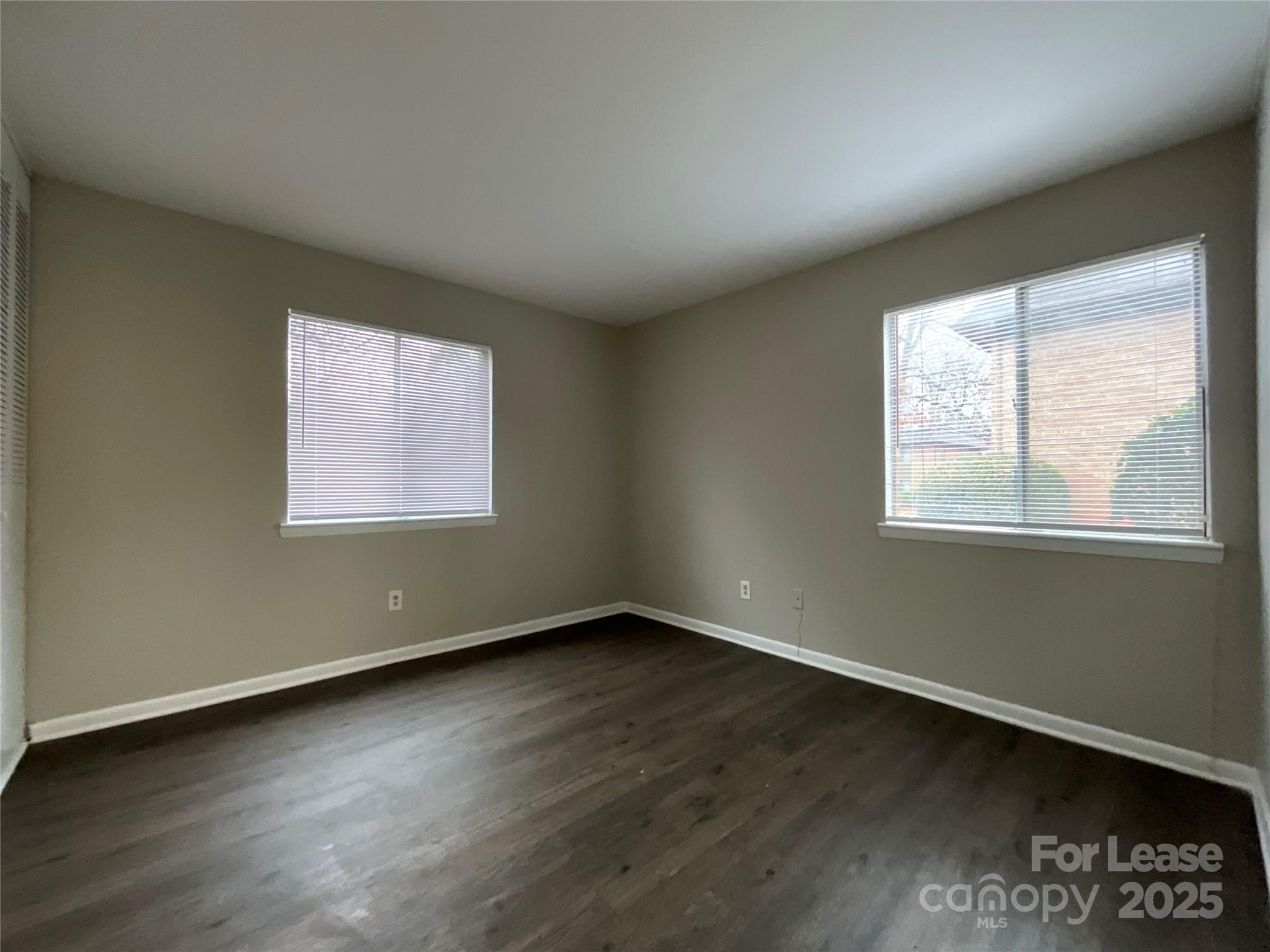 238 Orchard Trace Lane, Unit 2 Charlotte, NC 28213 - Photo 6 of 9 an empty room with wooden floor and windows