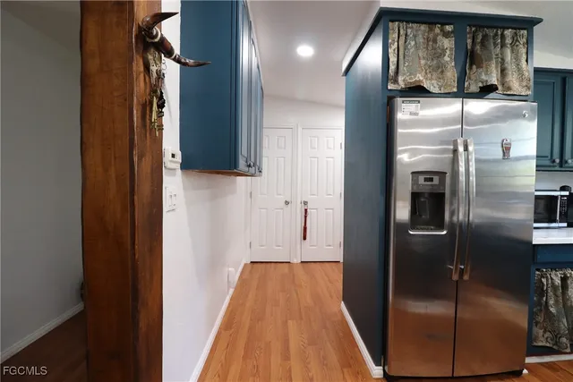 a view of hallway with stainless steel appliances granite countertop cabinets and a window