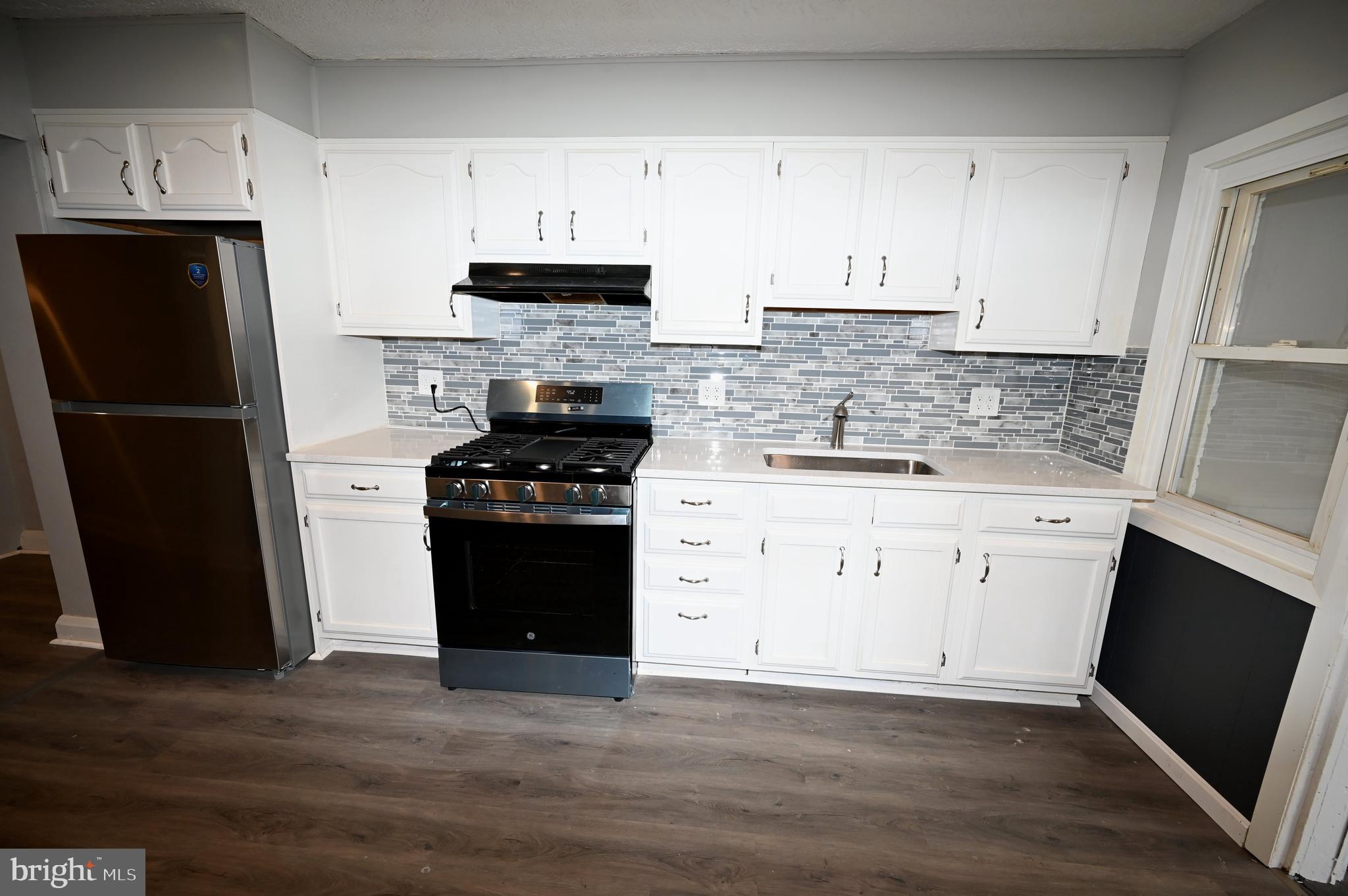 2952 Sollers Point Road, Unit B Dundalk, MD 21222 - Photo 24 of 37 a kitchen with a refrigerator stove and white cabinets
