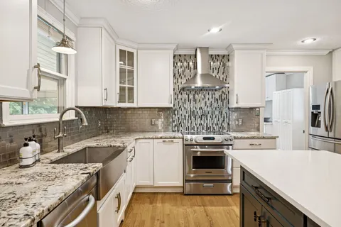 a kitchen with granite countertop a sink stove and refrigerator