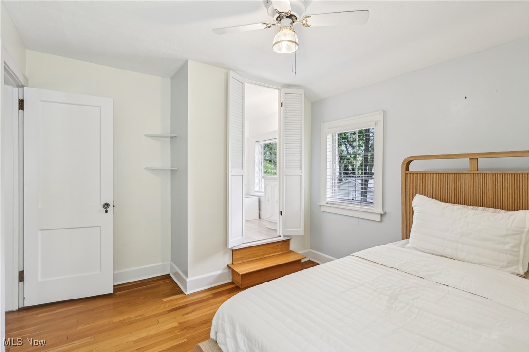 3295 Braemar Road Cleveland, OH 44120 - Photo 25 of 43 Bedroom with light wood floors, baseboards, and ceiling fan. En-suite bathroom is just up the steps.