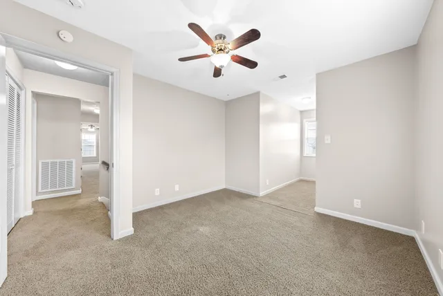 an empty room with closet and ceiling fan