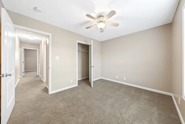 an empty room with chandelier fan