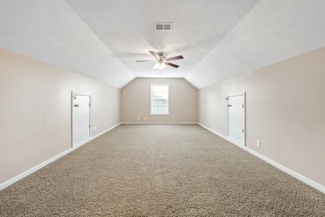an empty room with a window and a ceiling fan