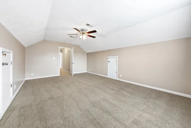 a view of an empty room with a ceiling fan