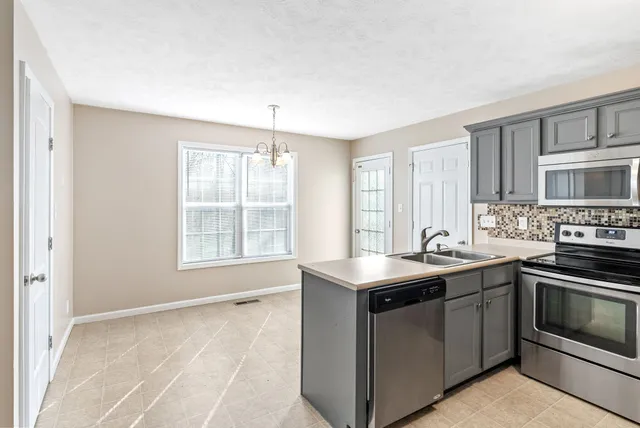 a kitchen with a sink stove top oven and cabinets