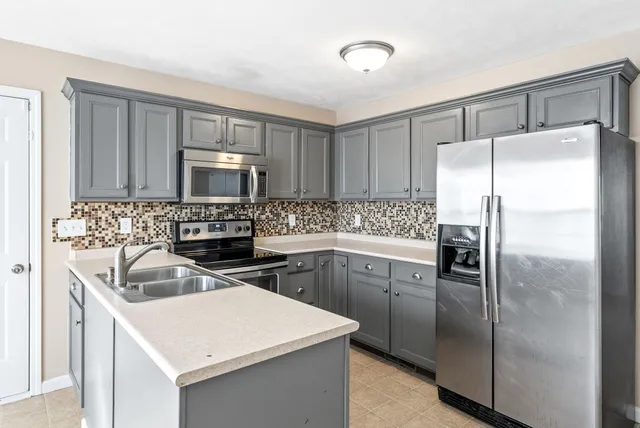 a kitchen with a sink a microwave a refrigerator and cabinets
