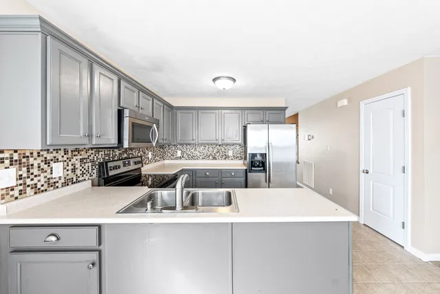 a kitchen with a sink a stove and cabinets