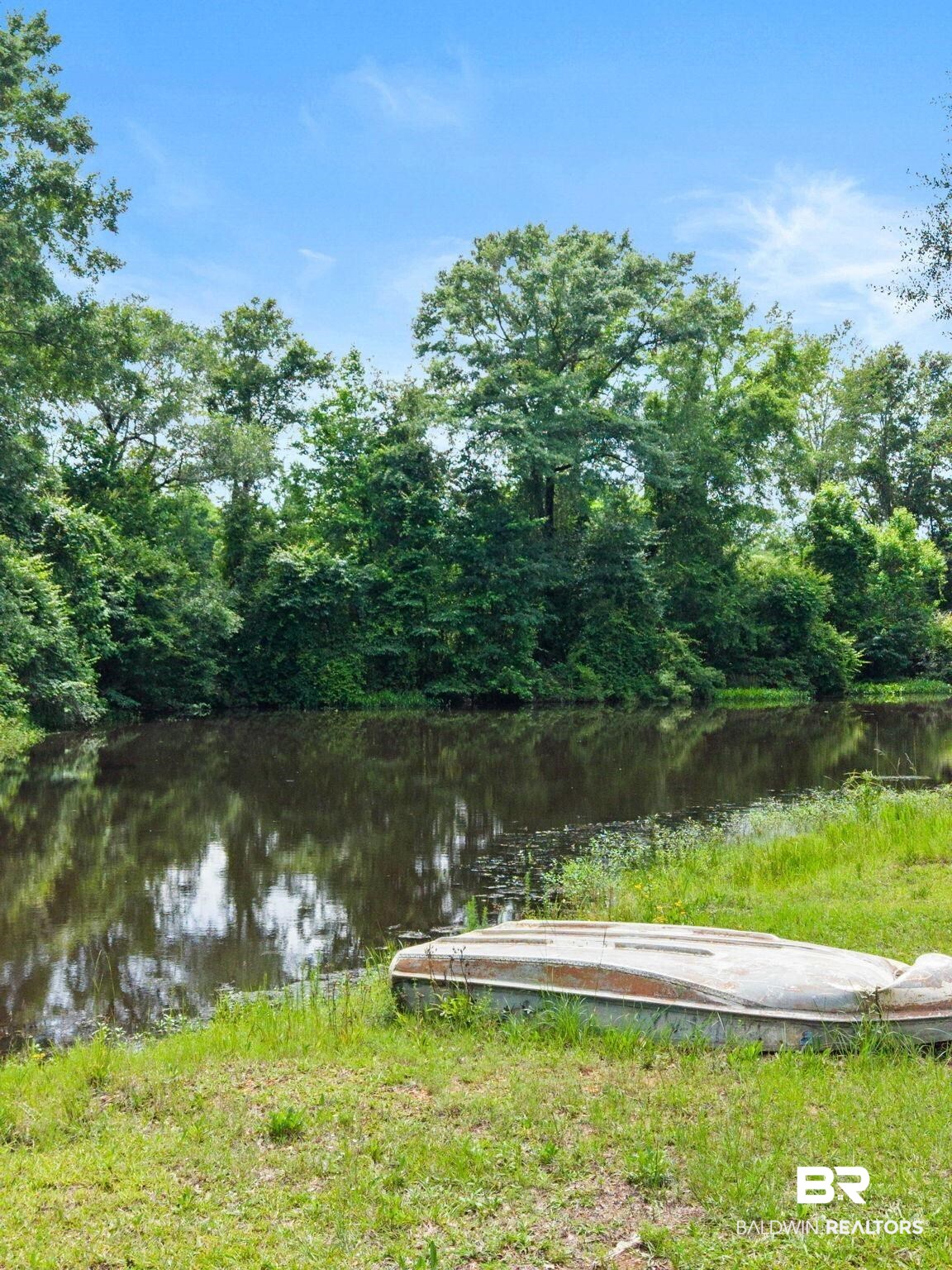 2029 George Lee Road Repton, AL 36475 - Photo 48 of 58 Waterfront property featuring a tranquil pond, surrounded by lush, mature trees and a grassy bank