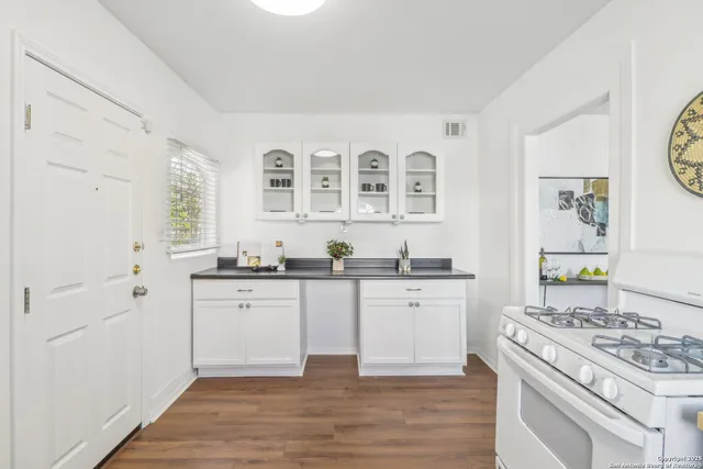 a kitchen with stainless steel appliances a stove a sink and white cabinets