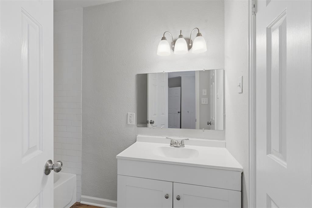 Bathroom featuring a textured wall and vanity