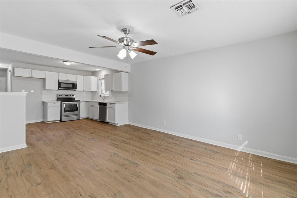 215 North Morrow Street Blue Ridge, TX 75424 - Photo 6 of 23 Kitchen with light wood-style floors, white cabinetry, light countertops, and stainless steel appliances