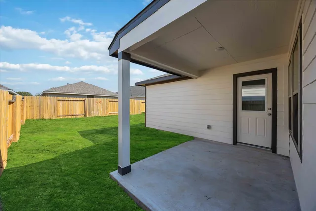 a view of a backyard with table and chairs and wooden fence