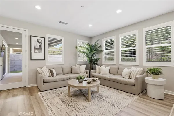 a kitchen with stainless steel appliances kitchen island granite countertop a dining table chairs and white cabinets