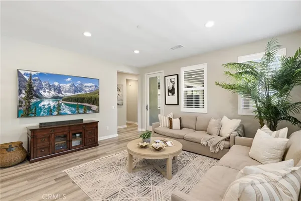 a kitchen with stainless steel appliances kitchen island granite countertop a table chairs stove and white cabinets