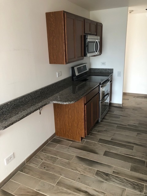 425 Walnut Creek Road, Unit 1608 Lisle, IL 60532 - Photo 2 of 13 a kitchen with kitchen island a sink stove and wooden cabinets