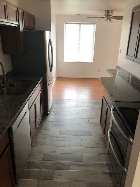 425 Walnut Creek Road, Unit 1608 Lisle, IL 60532 - Photo 5 of 13 a kitchen with granite countertop a refrigerator and a stove