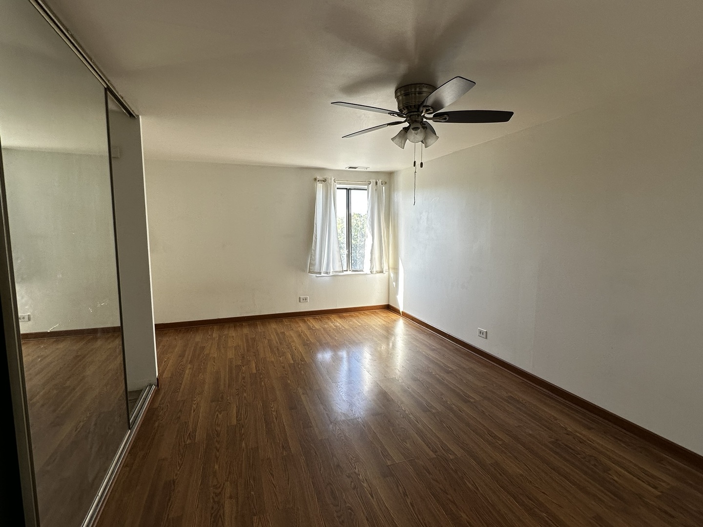 425 Walnut Creek Road, Unit 1608 Lisle, IL 60532 - Photo 9 of 13 a view of empty room with wooden floor and fan