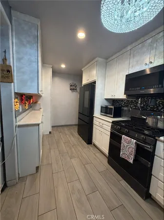 a kitchen with stainless steel appliances granite countertop a refrigerator and a stove