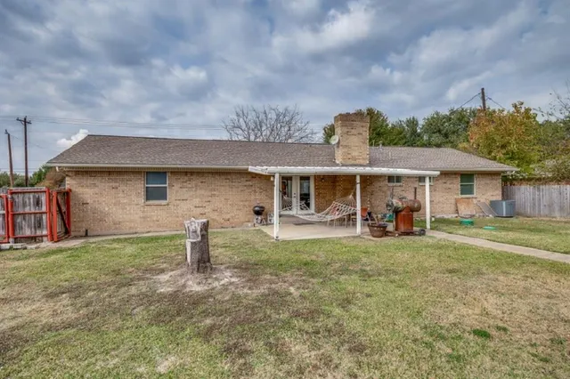 a front view of house with yard barbeque and outdoor seating