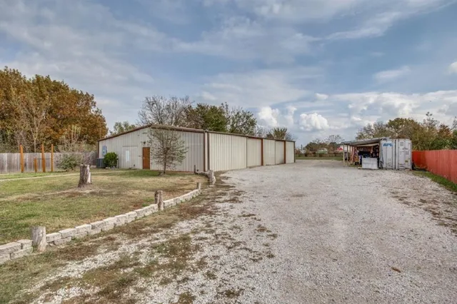 a view of a dry yard with wooden fence