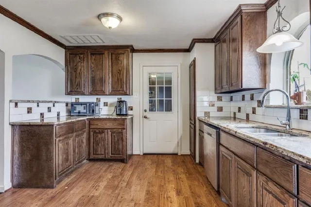 a kitchen with stainless steel appliances granite countertop a sink stove and cabinets