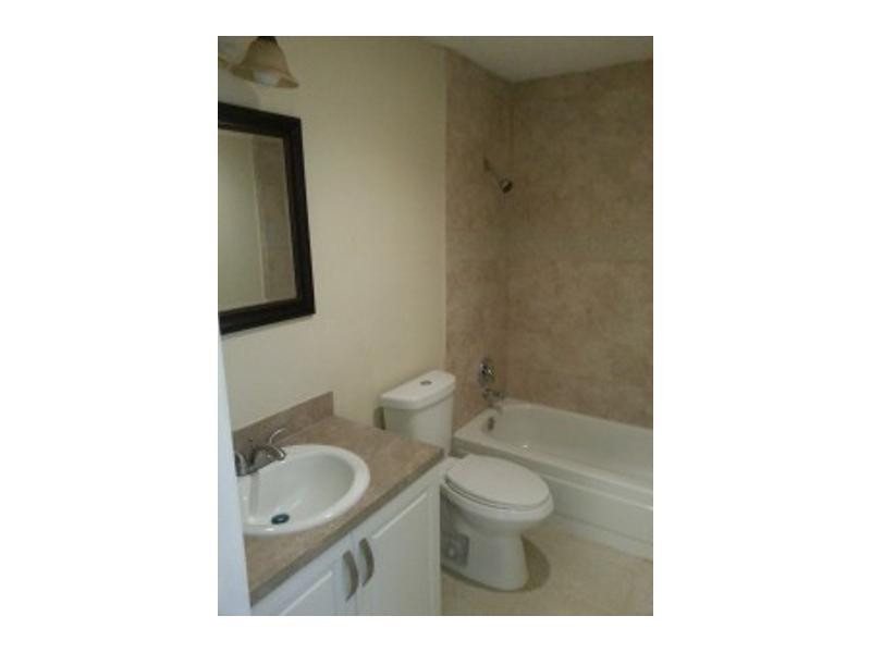 6345 Southwest 138th Court, Unit 102 Miami, FL 33183 - Photo 5 of 6 a bathroom with a toilet a sink and mirror