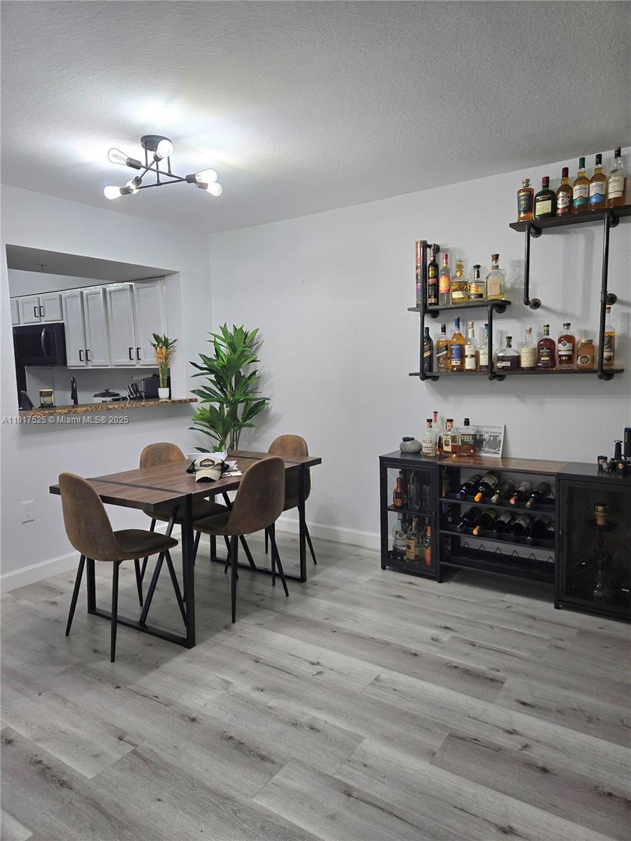 22311 Southwest 88th Place, Unit 2044 Cutler Bay, FL 33190 - Photo 3 of 7 a view of a dining room with furniture and wooden floor