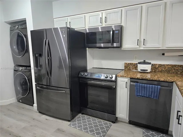 a kitchen with stainless steel appliances granite countertop a refrigerator and a stove top oven