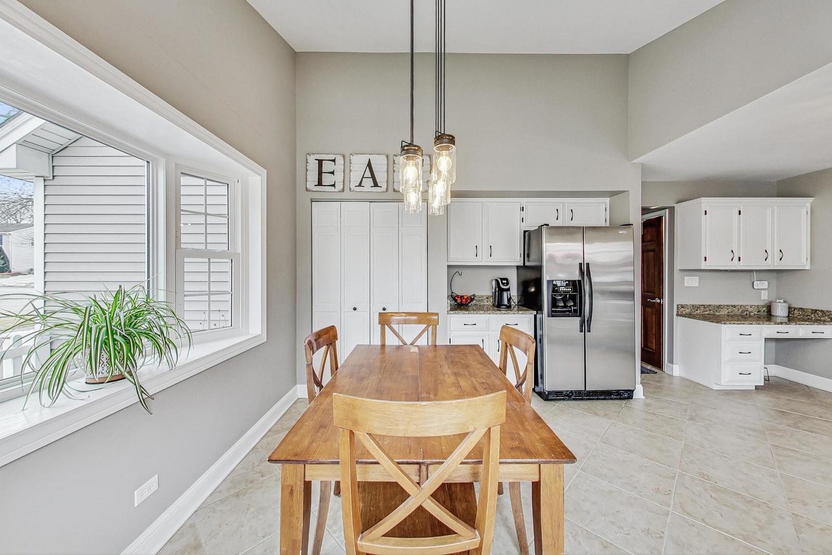 1345 East Bailey Road Naperville, IL 60565 - Photo 12 of 49 a kitchen with stainless steel appliances kitchen island granite countertop a refrigerator a stove a sink dishwasher and white cabinets with wooden floor