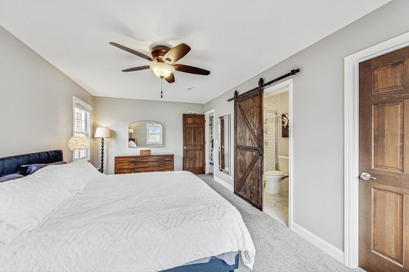 1345 East Bailey Road Naperville, IL 60565 - Photo 20 of 49 a bedroom with a large bed and a chandelier