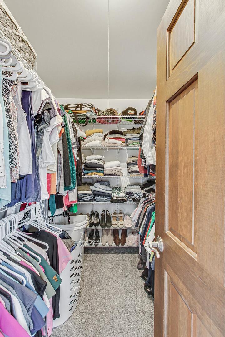 1345 East Bailey Road Naperville, IL 60565 - Photo 21 of 49 a view of walk in closet with clothes and shoes