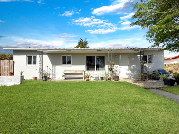 a front view of house with yard and chairs
