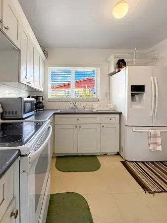 a kitchen with granite countertop a sink stainless steel appliances and cabinets