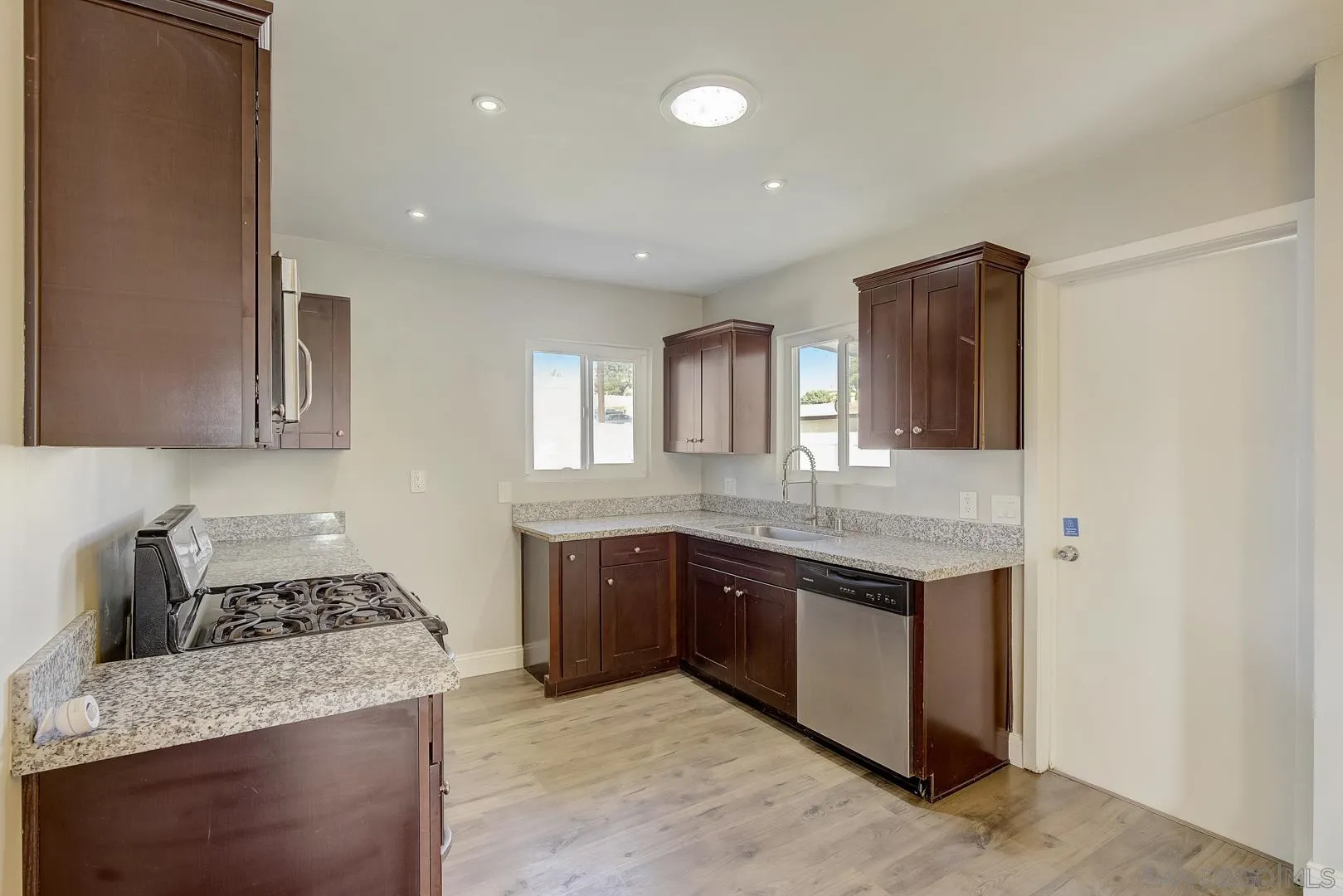 9060 Rosedale Drive Spring Valley, CA 91977 - Photo 17 of 28 a kitchen with a sink and a stove top oven with wooden floor