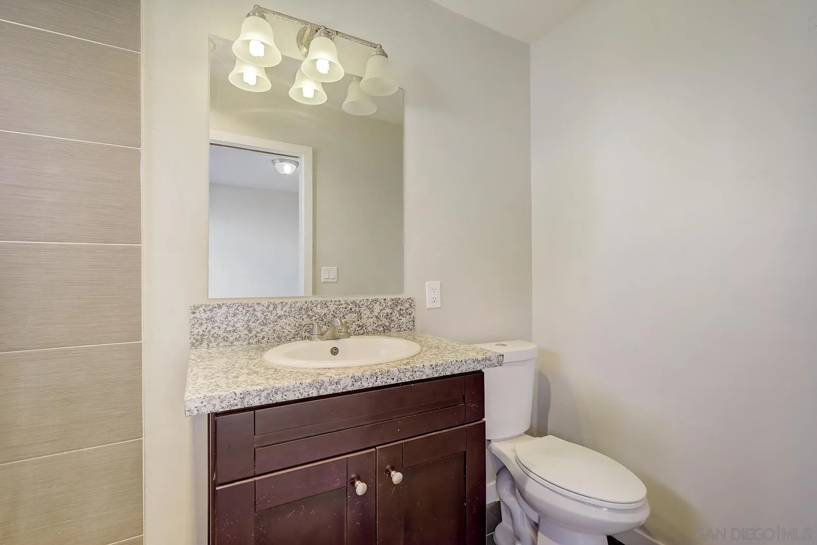 9060 Rosedale Drive Spring Valley, CA 91977 - Photo 20 of 28 a bathroom with a granite countertop toilet sink and mirror