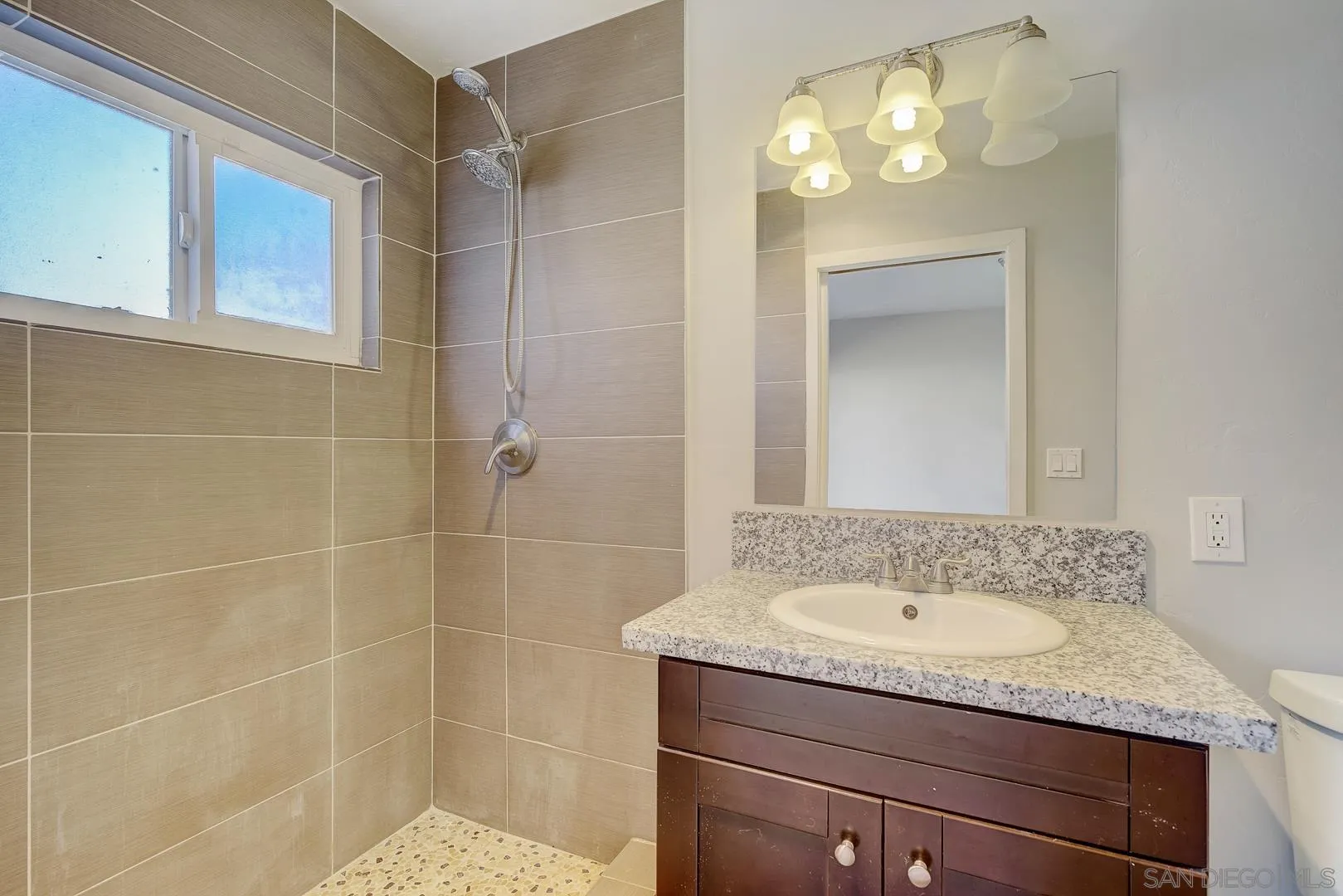 9060 Rosedale Drive Spring Valley, CA 91977 - Photo 8 of 28 a bathroom with a granite countertop sink a mirror and a shower