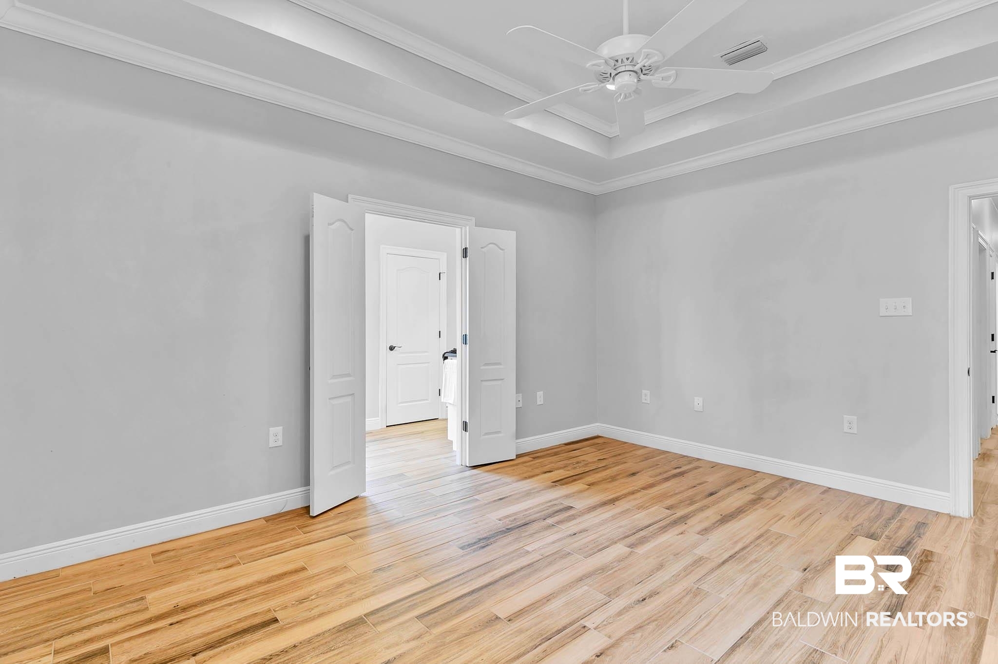 8145 Bay View Drive Foley, AL 36535 - Photo 28 of 81 Primary Bedroom featuring crown molding, a ceiling fan, light wood-tile floors, and a tray ceiling