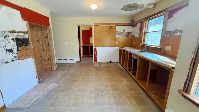 a view of a kitchen with fridge and wooden floor