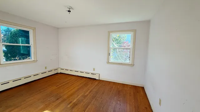 a view of a room with wooden floor and window