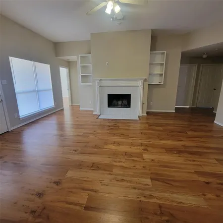 a view of a livingroom with wooden floor and a fireplace