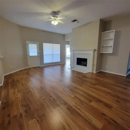 a view of an empty room with a fireplace and a window