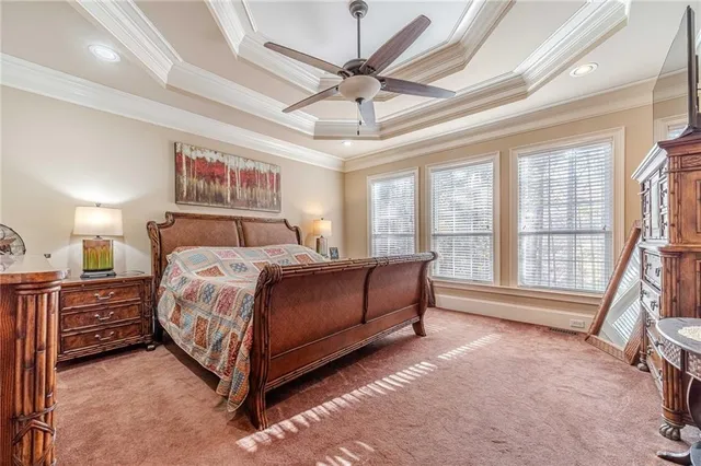 an empty room with wooden floor and way to kitchen