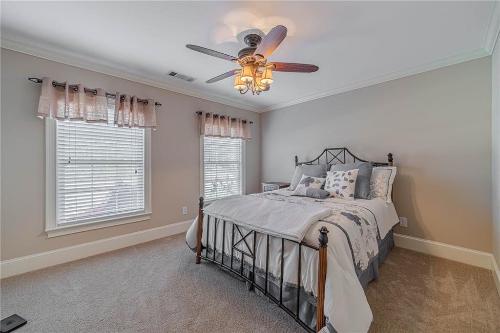 686 Newton Factory Bridge Road Covington, GA 30014 - Photo 42 of 110 a bedroom with a bed and a chandelier